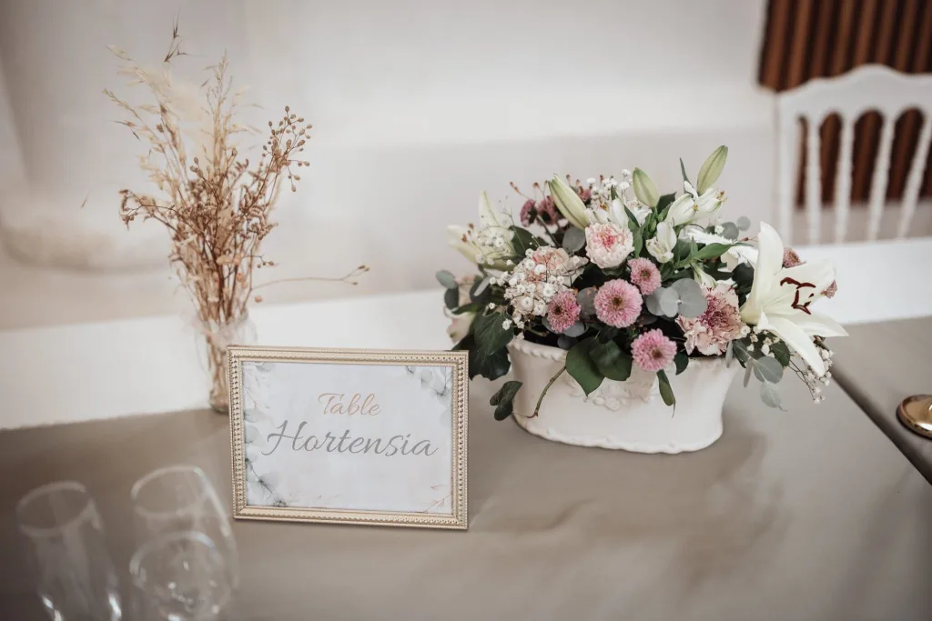 Nom de table « Hortensia » et composition florale rose et blanche pour un mariage