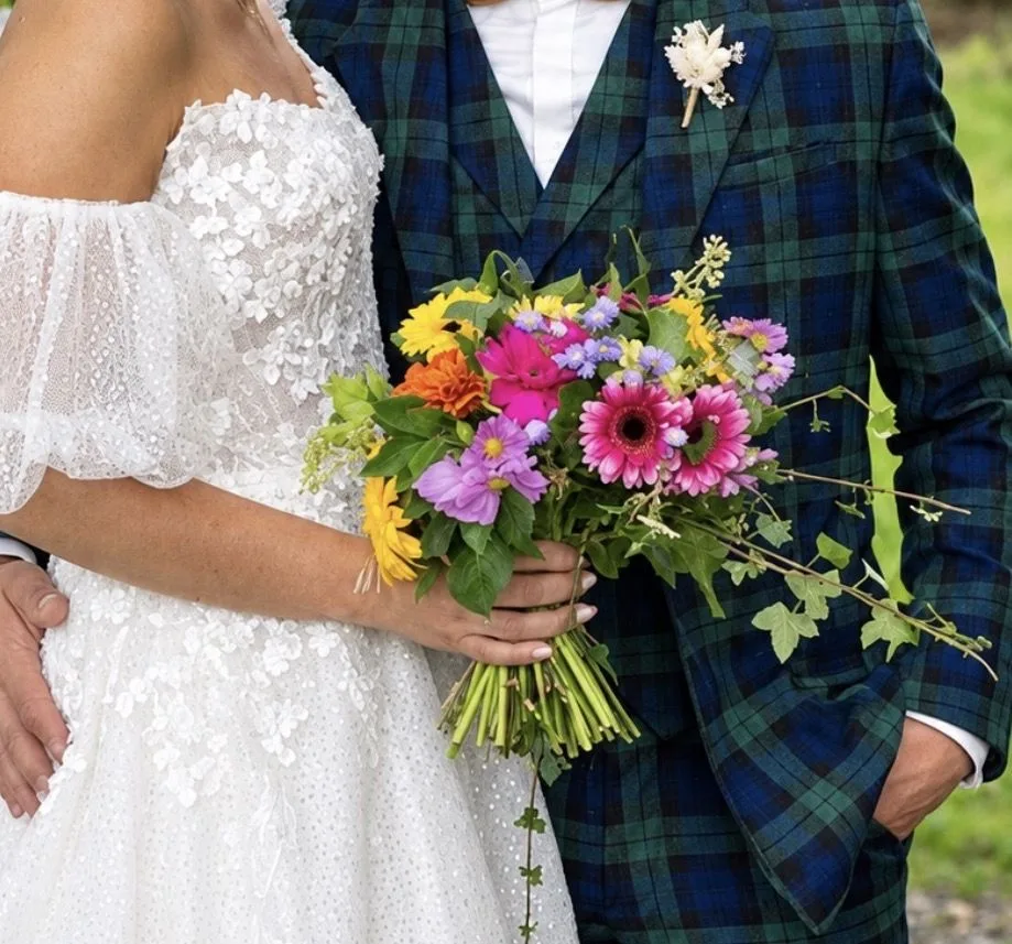Bouquet de mariée multicolore de gerberas, zinnias et asters, avec du lierre retombant