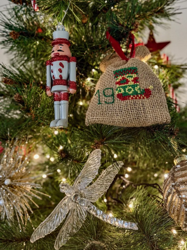 Décorations de Noël faites main dans un sapin : casse-noisette, libellule et pochon brodé numéro 19
