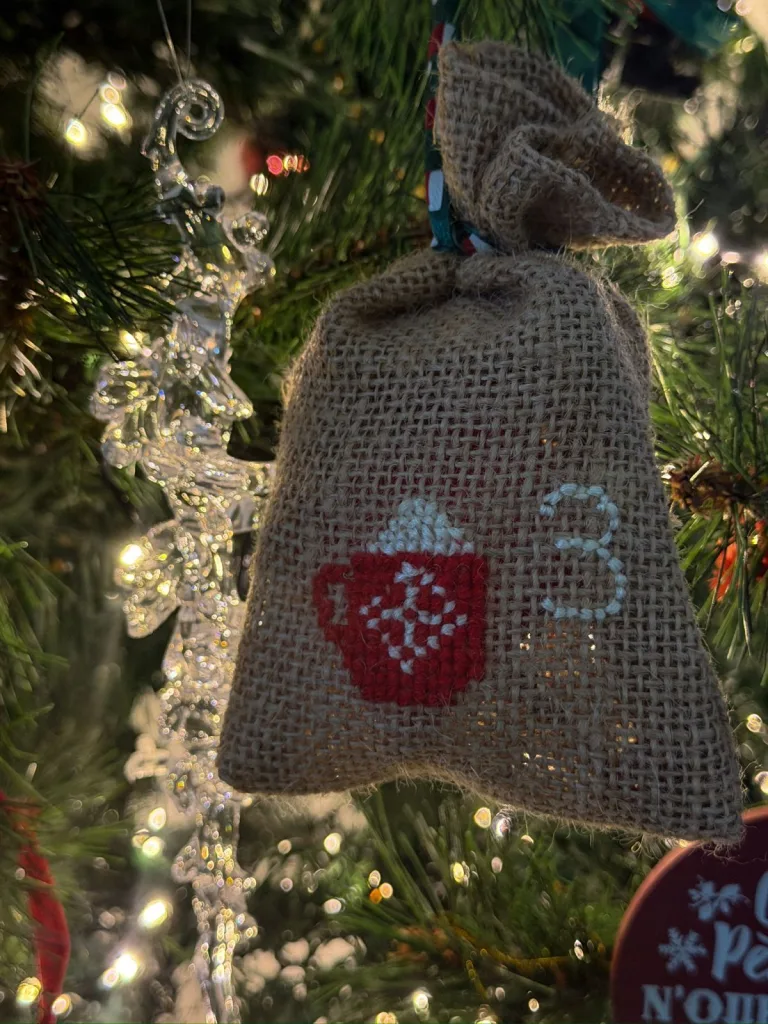 Pochon en toile de jute brodé au point de croix d’une tasse rouge et du chiffre 3