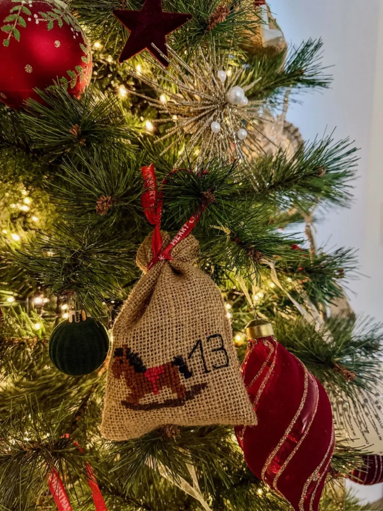 Pochon de calendrier de l’Avent en toile de jute brodé d’un cheval à bascule et du chiffre 13